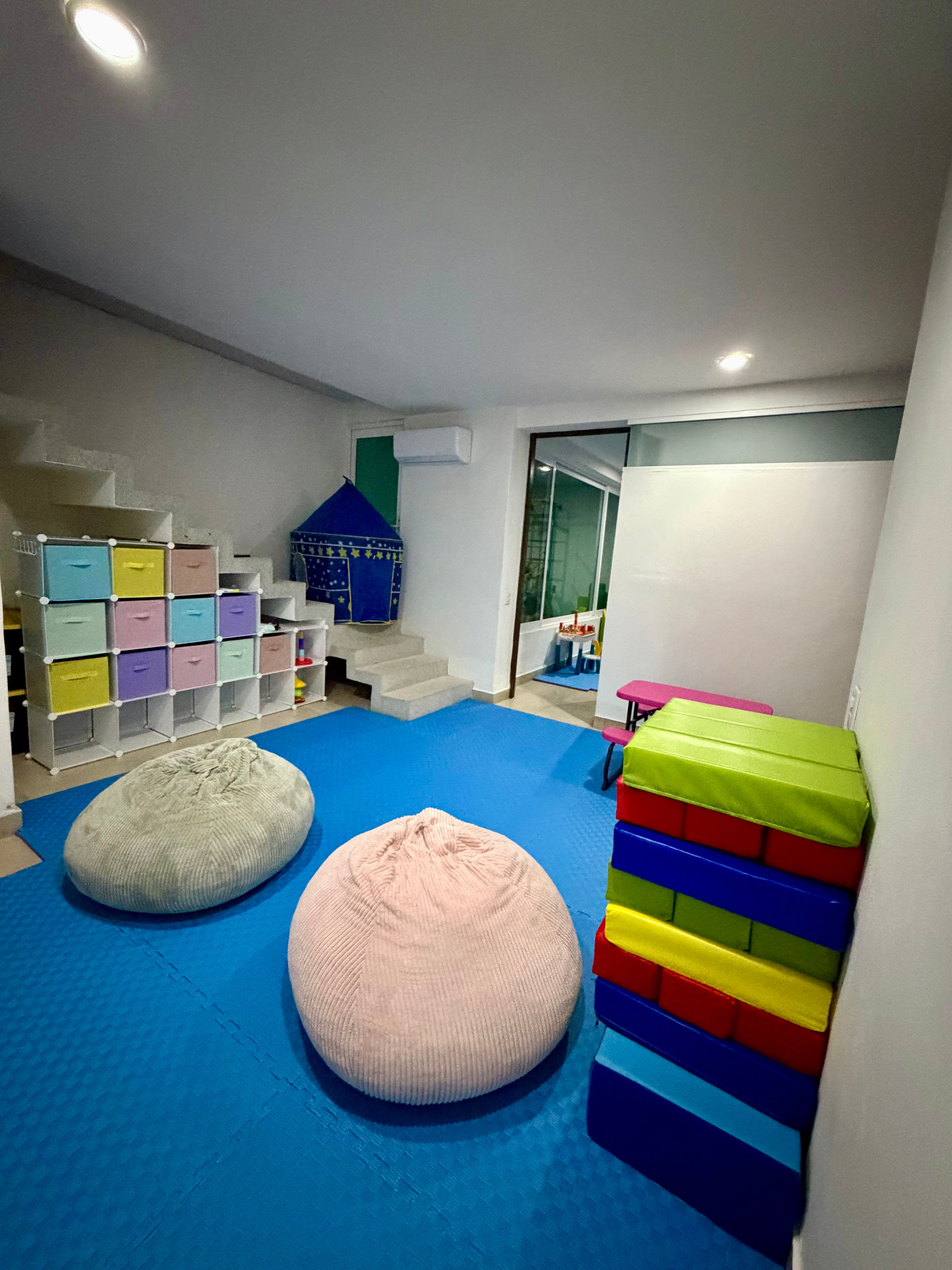 Zona de descanso y actividades didácticas para niños en Ludo Mix Puerto Vallarta, con pufs y materiales organizados